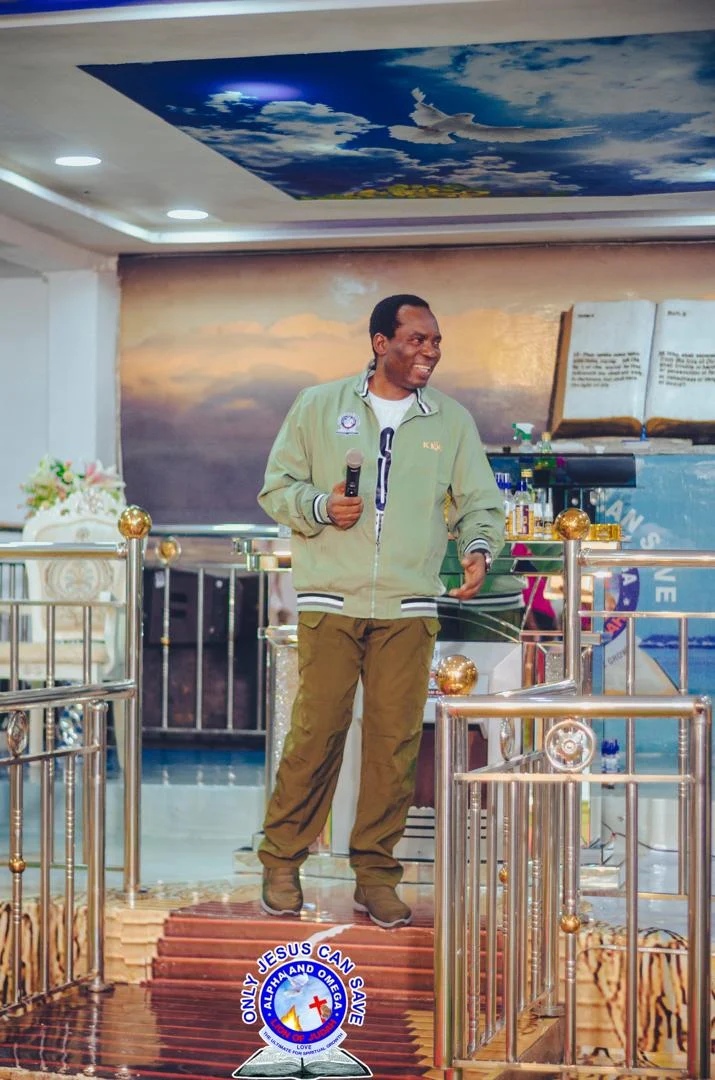 Pst. Akpos Joseph Ekiegha JP standing at the sanctuary prayer altar platform by the golden bell
